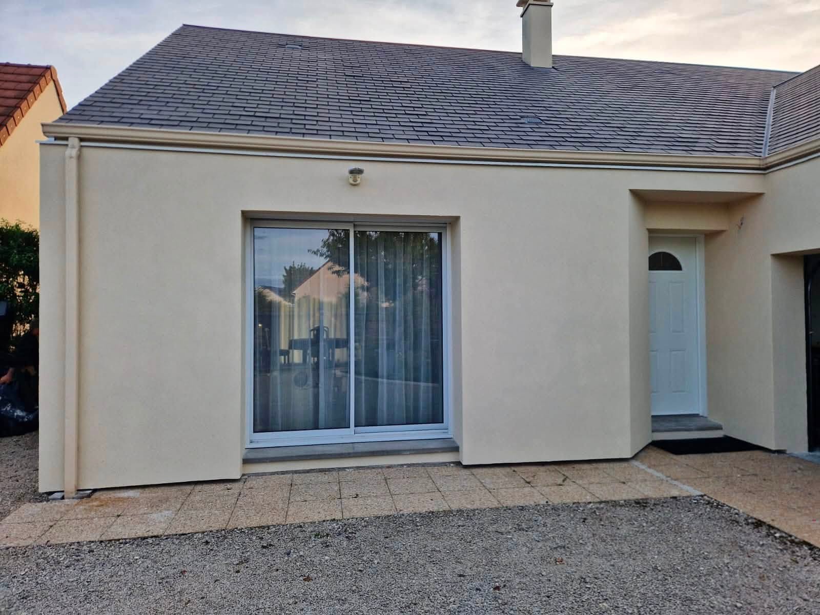 Réalisation BM Action : façade claire avec baie vitrée et porte d’entrée