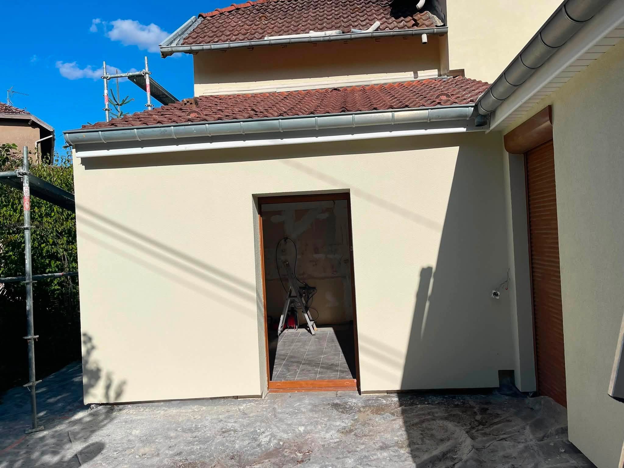 Réalisation BM Action : façade enduite pendant le chantier, avec échafaudage et protections
